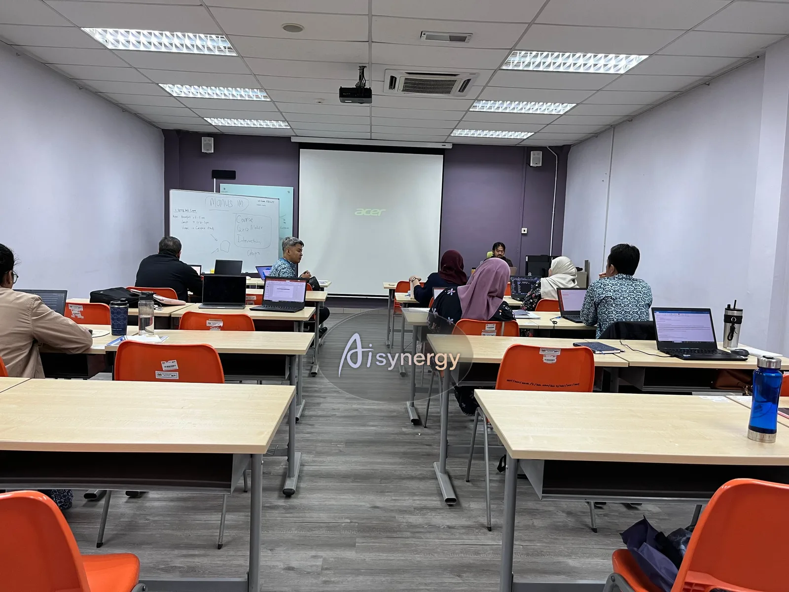 Training session in progress in a client meeting room, participants working at laptops
